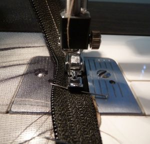 Closeup of seam connecting two pieces of black mosquito mesh
