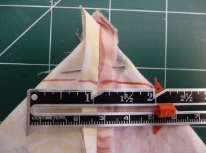 Corner of floral fabric with seam gauge showing 2" wide corner