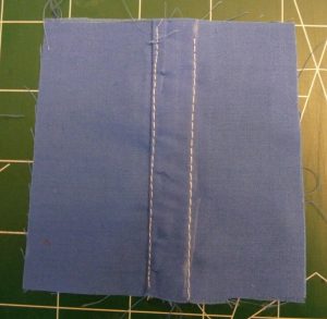 Double lapped seam sewn in blue fabric with white thread