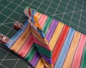 Oblique view of a zipper pouch with vertical stripes