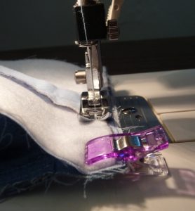 Close up of purple sewing clip & universal presser foot sewing a seam